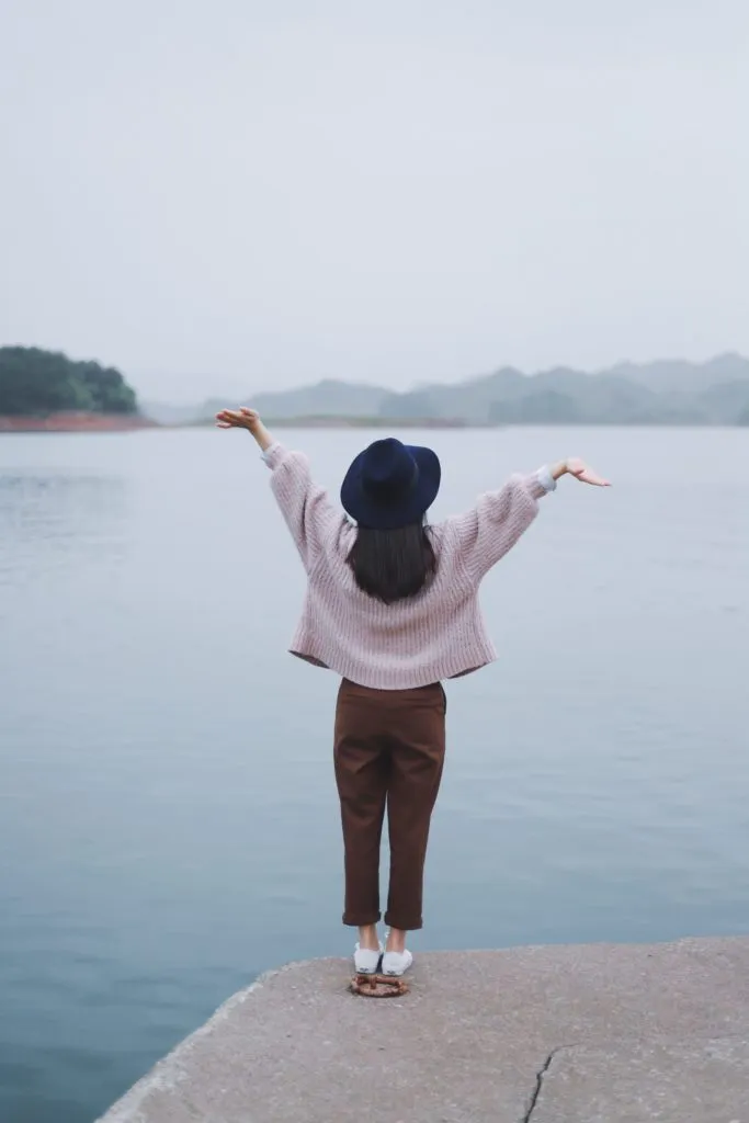 A woman looking out across a quiet lake